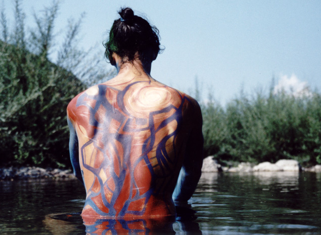 Modèle masculin, performance en body-painting dans un cours d'eau.
